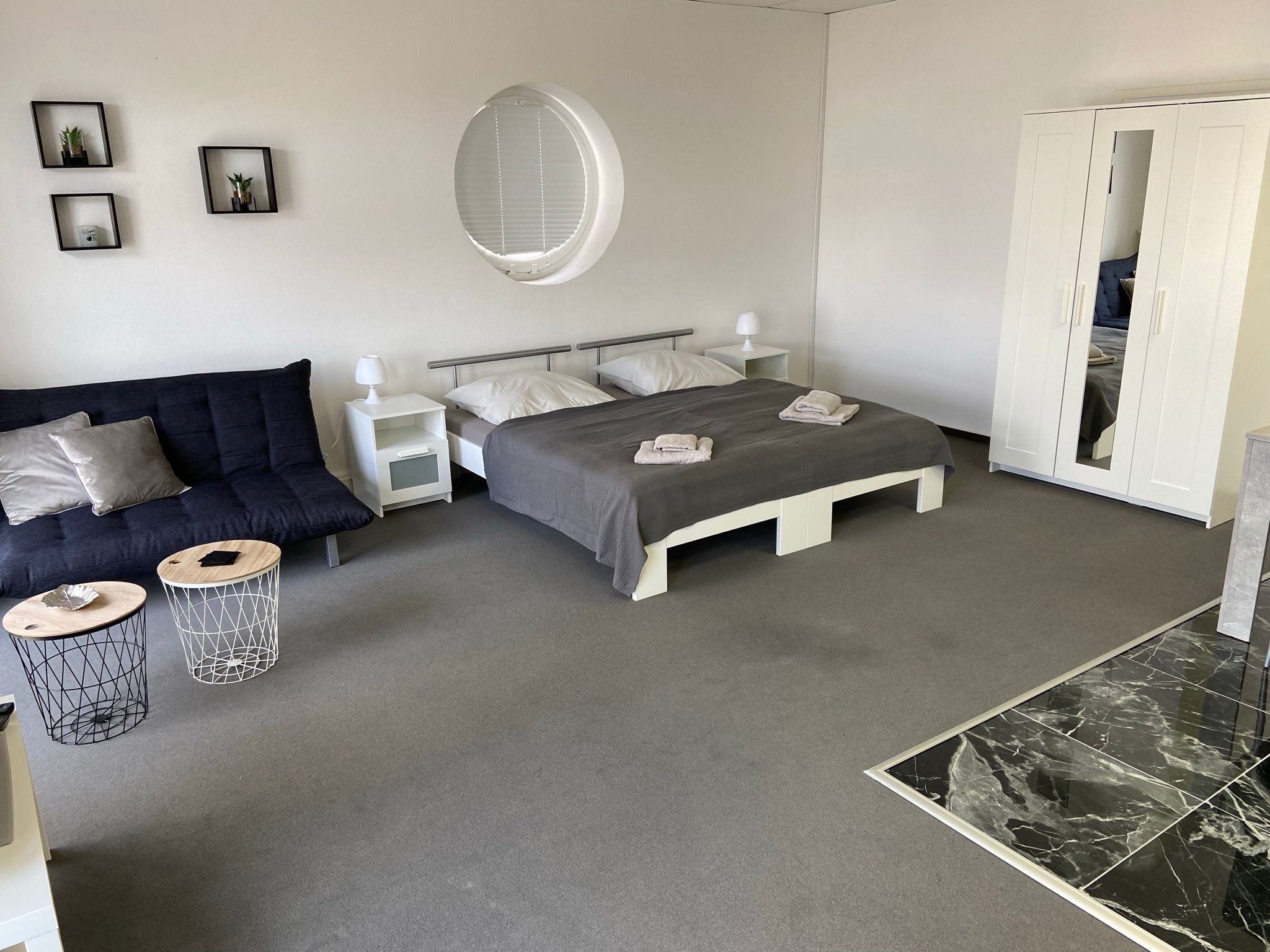 Wohnzimmer mit blauem Sofa und Essbereich