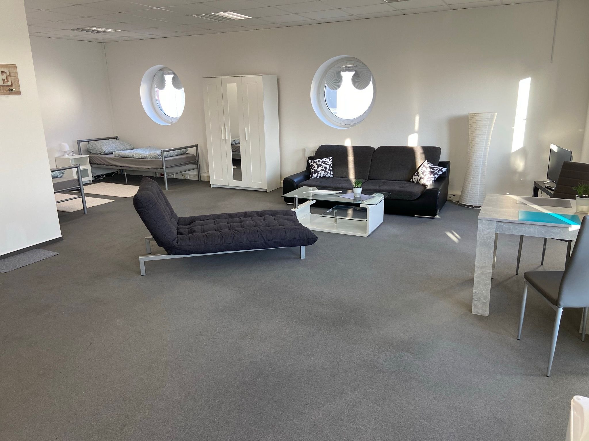 Helles Wohnzimmer mit Sofa und TV-Regal